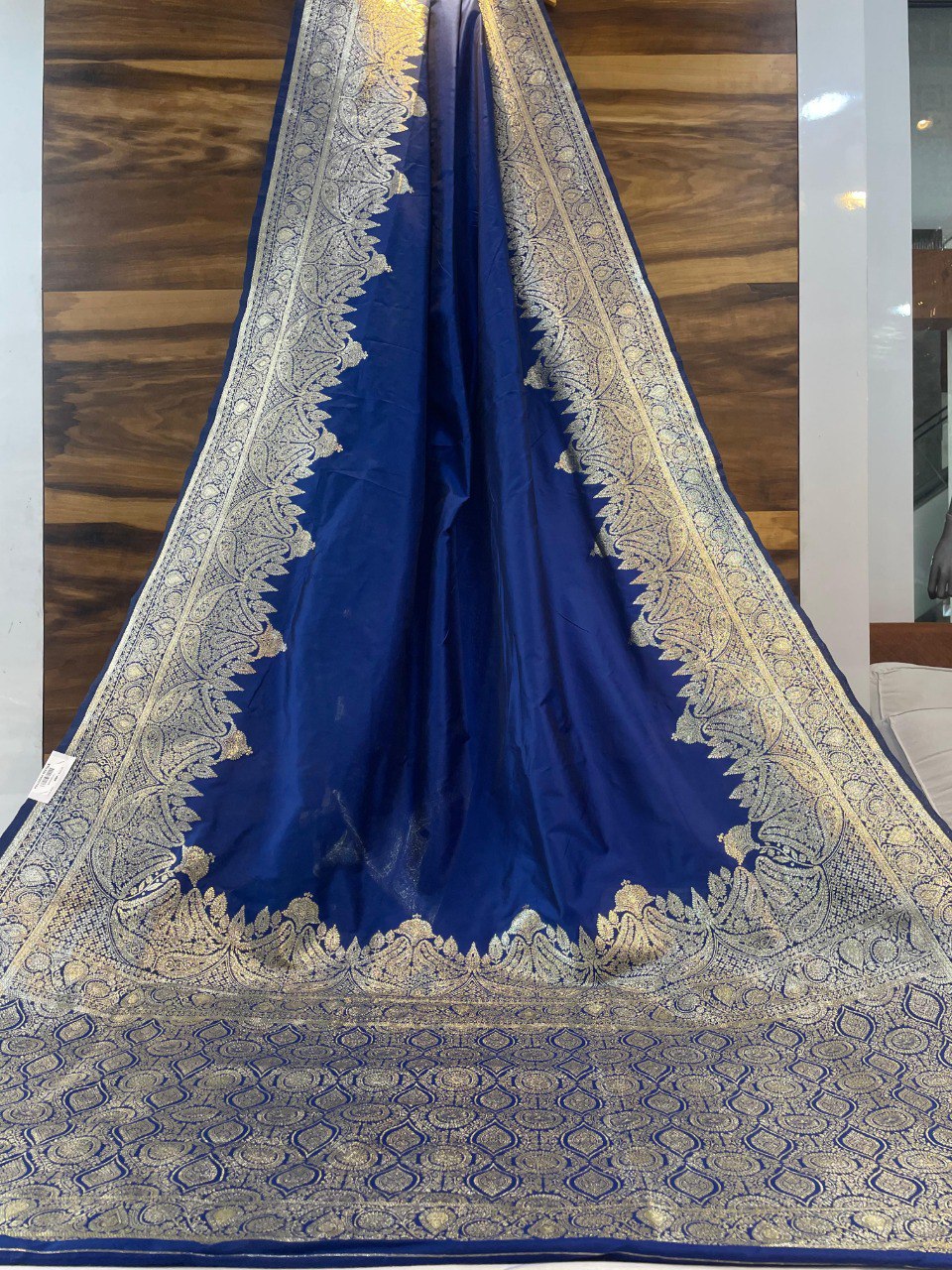 Royal blue Banarasi silk saree with intricate gold zari border and pallu, gracefully displayed.
