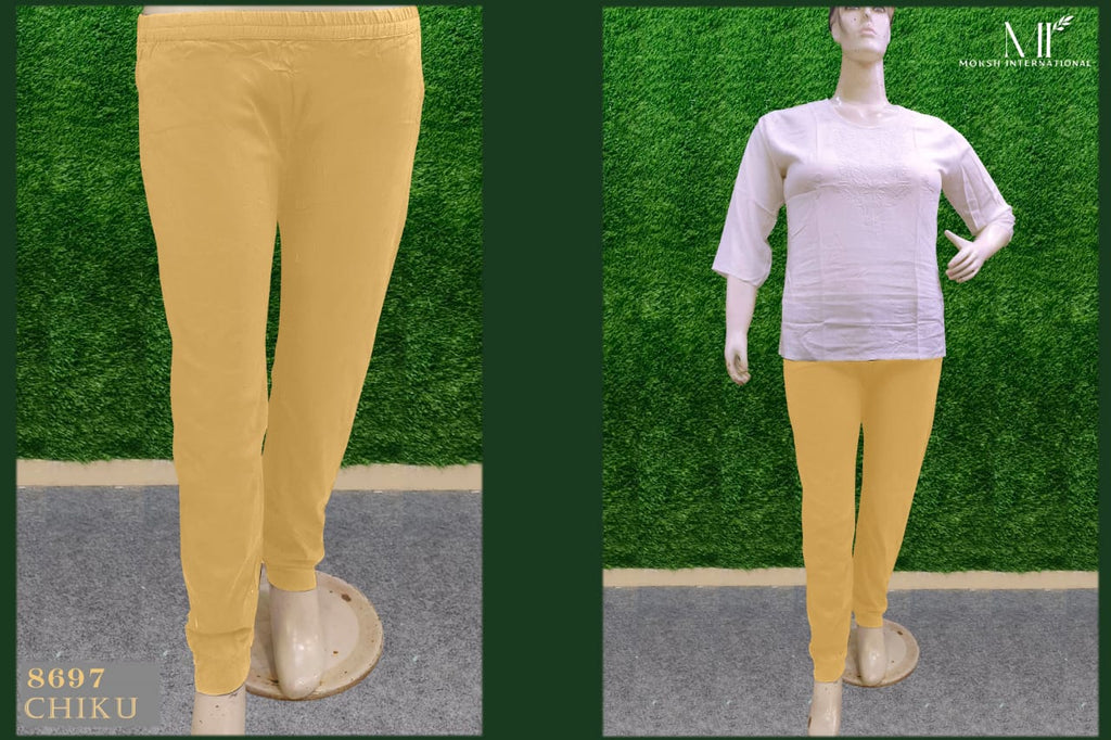 Full-length Chiku (light yellow/beige) Riyon pant on a mannequin, paired with a white top, against a grass-like background.