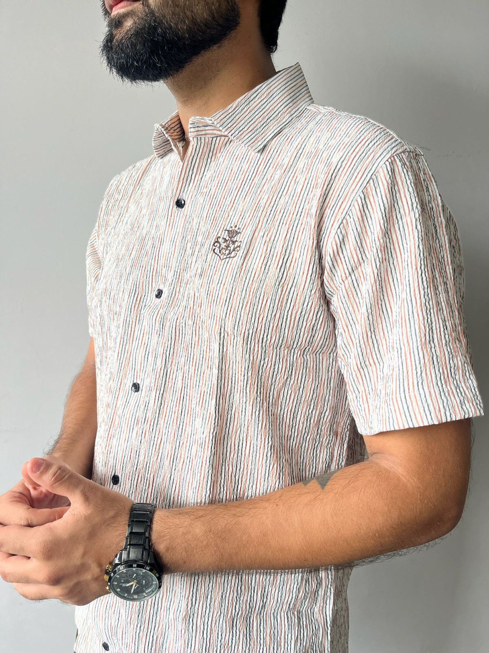Close-up of man in Anchor Logo Beige & Brown Stripe Popcorn Shirt, showcasing textured fabric.