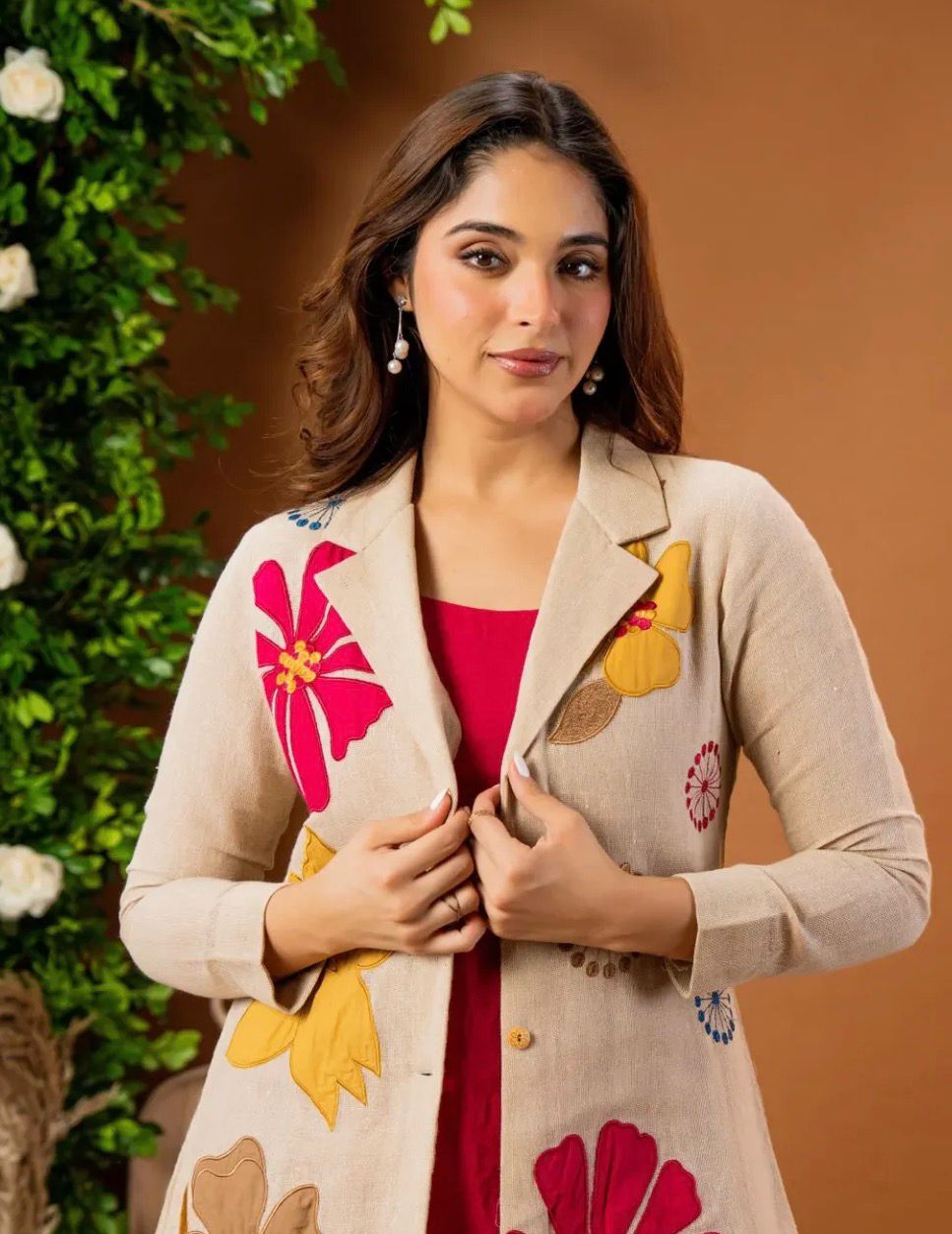 Close-up of a woman smiling, wearing a TRENDBUY beige cotton flax embroidered blazer over a fuchsia top.