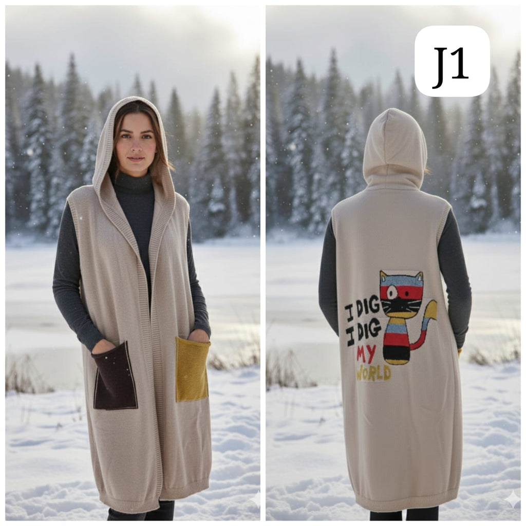 TRENDBUY Series J1: Woman in a long beige hooded woolen vest with colorful pocket details and a 'I DIG MY WORLD' cat graphic on the back, standing in a snowy landscape.