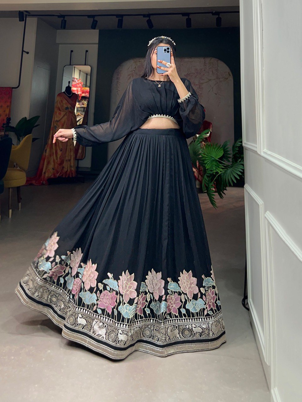 Model twirling in a black georgette lehenga co-ord set, showcasing vibrant floral and elephant thread embroidery with sequins on the hem.