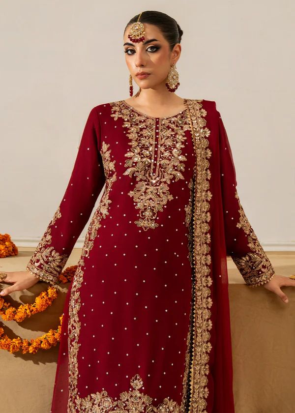 Model wearing a maroon Faux Georgette Sharara suit with gold sequin and moti embroidery, looking elegant