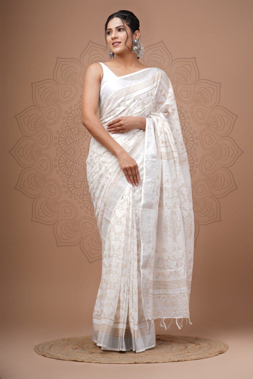 Model showcasing a beautiful off-white linen digital printed saree with subtle brown patterns and a silver zari border, standing against a neutral background.