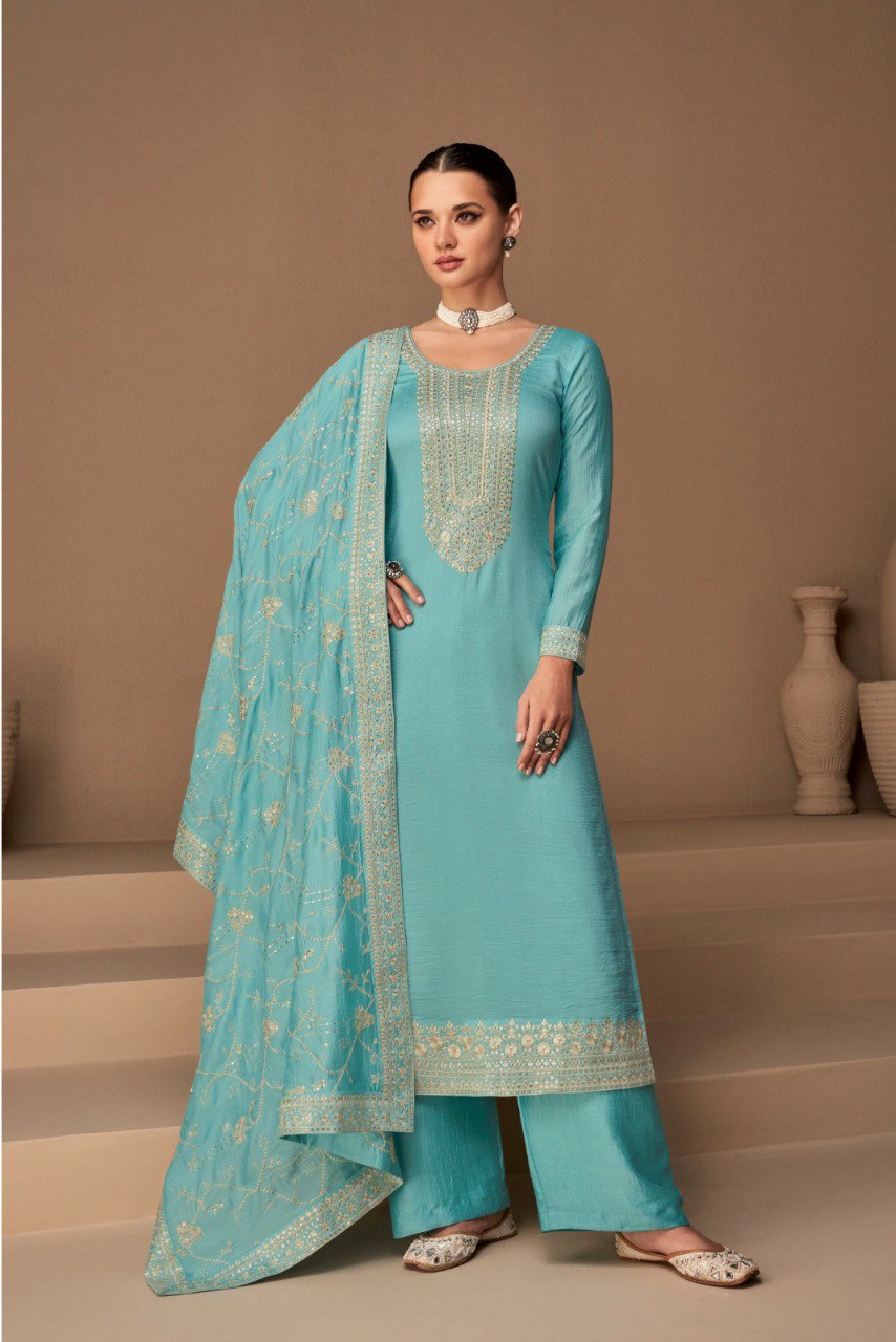 Model in a beautiful aqua blue heavy vichitra silk unstitched salwar suit with sequin and embroidery work.