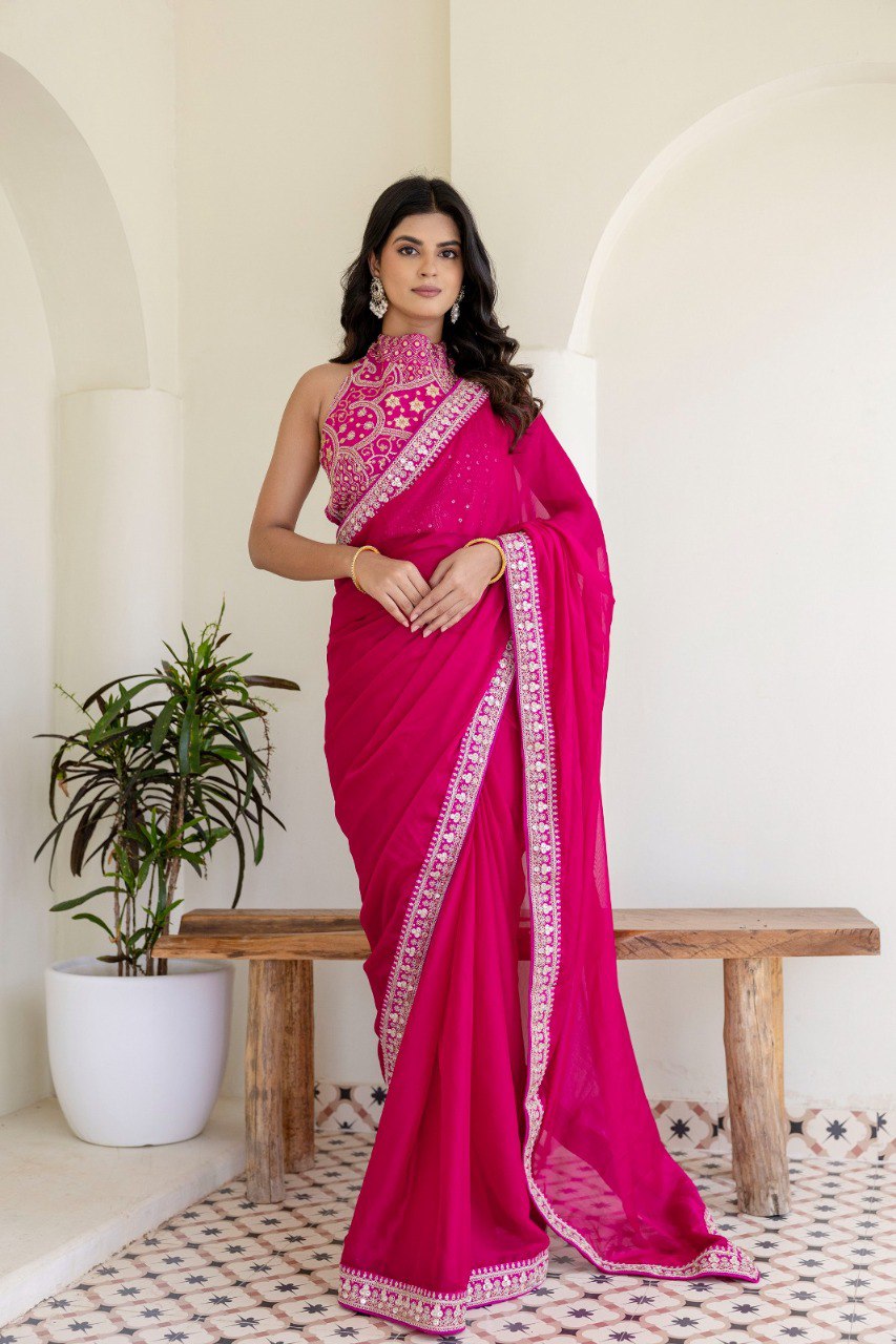 Full shot of model in hot pink Rangoli silk saree with cording and double sequins, standing elegantly against a white wall.