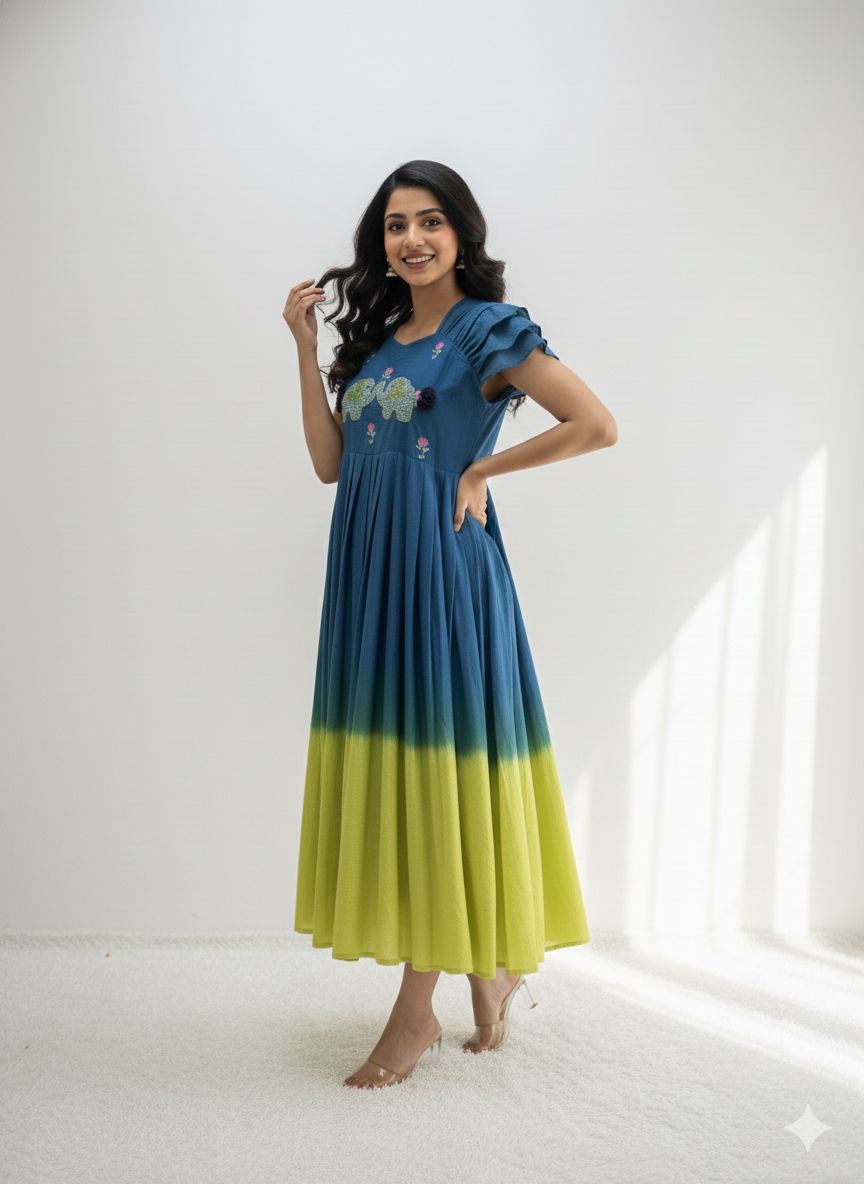 Woman smiling gracefully in a blue and lime green ombre handwork mul cotton gown, side pose.