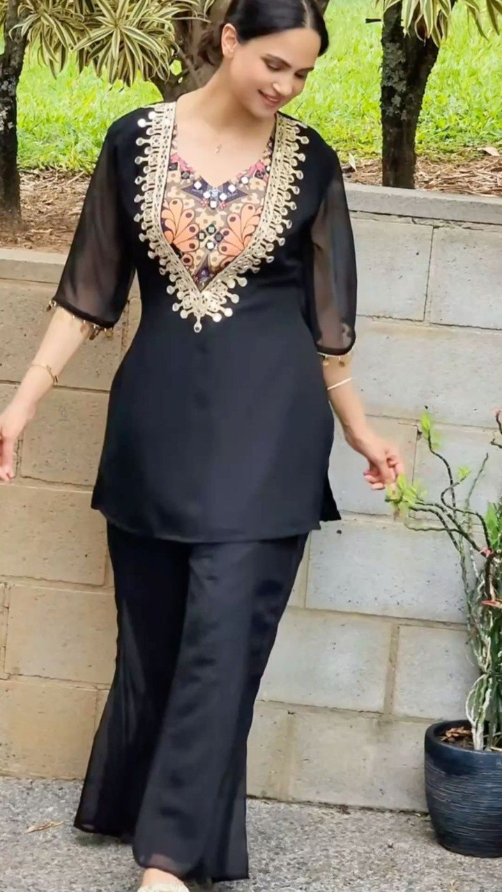 Woman wearing elegant black embroidered organza palazzo suit set for party wear.