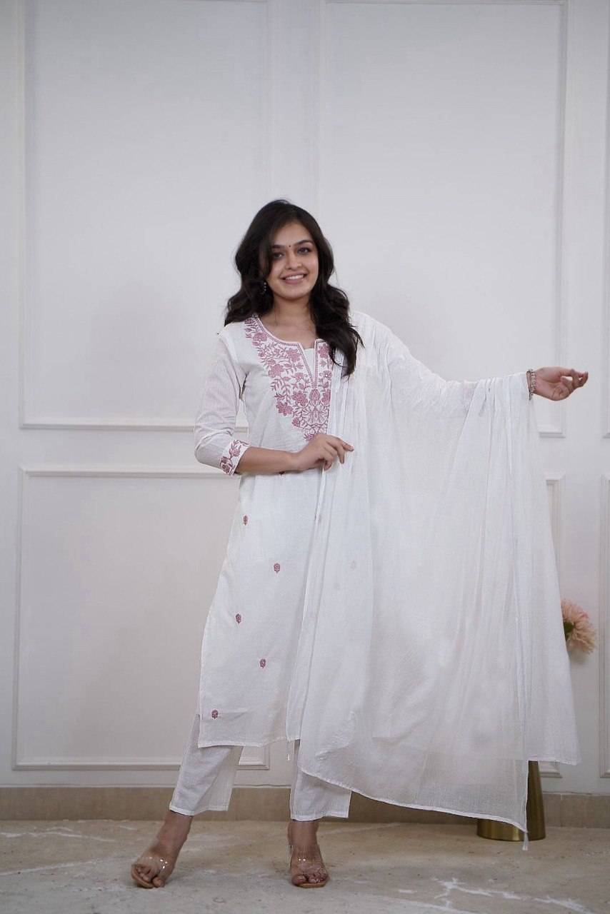 Woman posing in white embroidered Vertican Silk kurta set with pink embroidery and white dupatta.