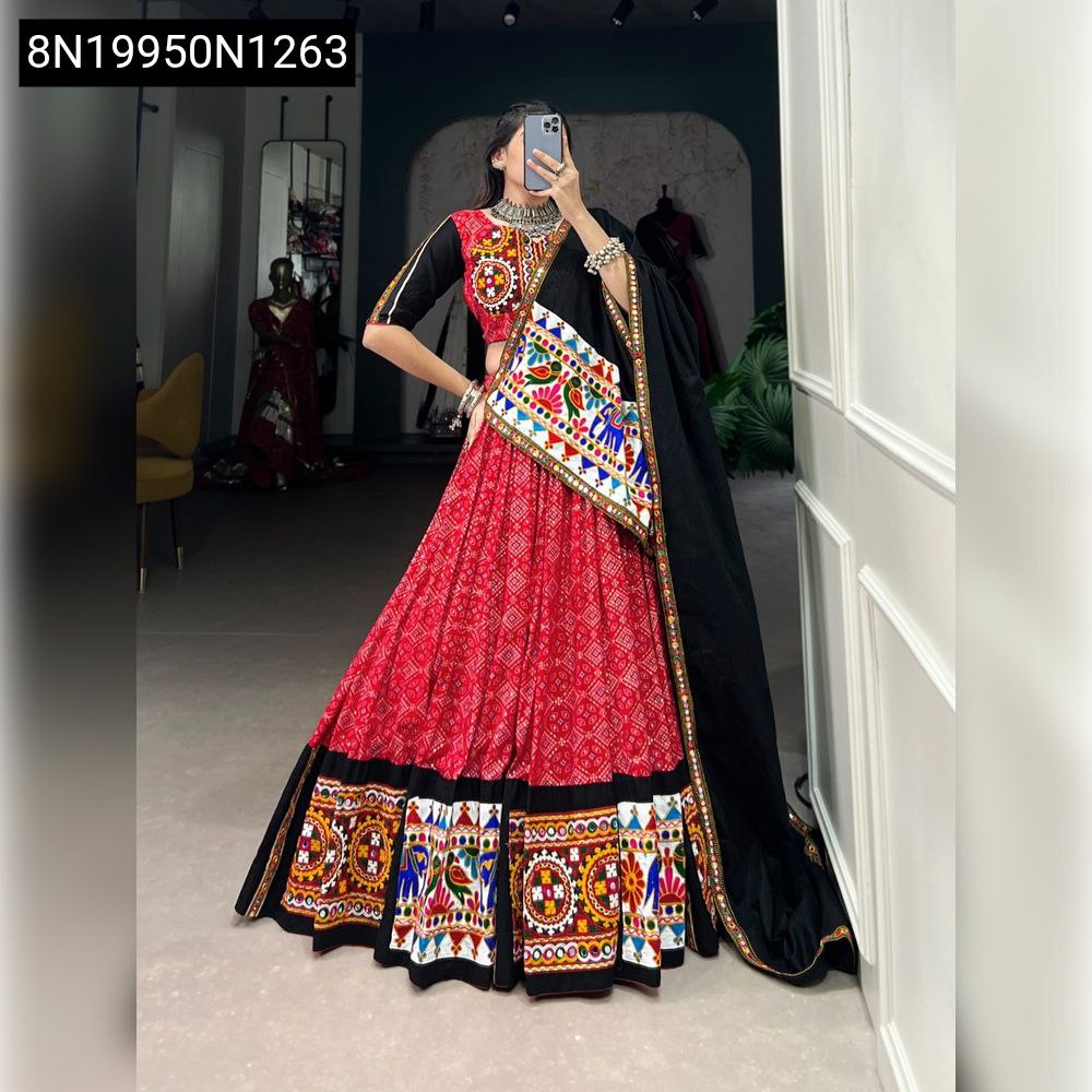 Model posing in red Gamthi mirror work lehenga choli with black blouse and dupatta.
