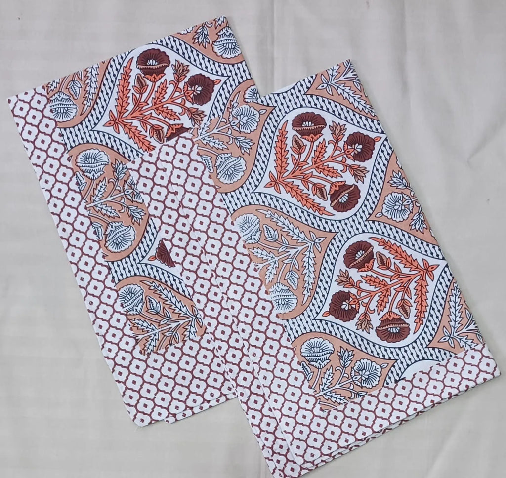 Beige and peach floral print cotton pillow covers folded neatly