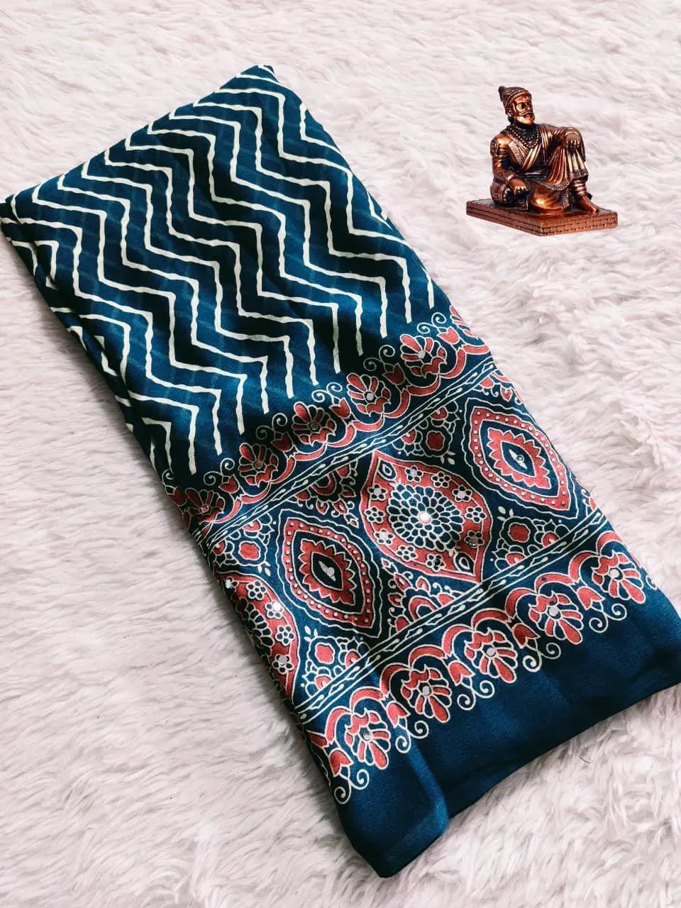 Folded navy blue satin saree with cream leheriya pattern and red ajrak border