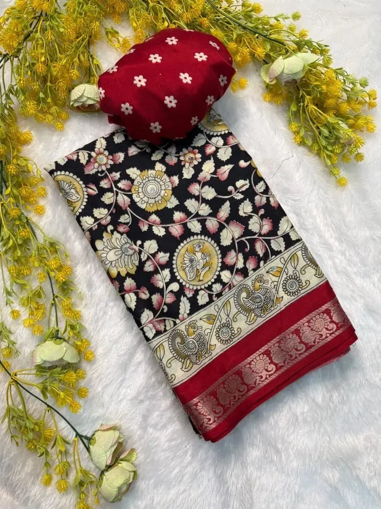 Folded black and red Ajrakh Gajji crepe silk saree with a red patterned blouse piece on a white plush rug