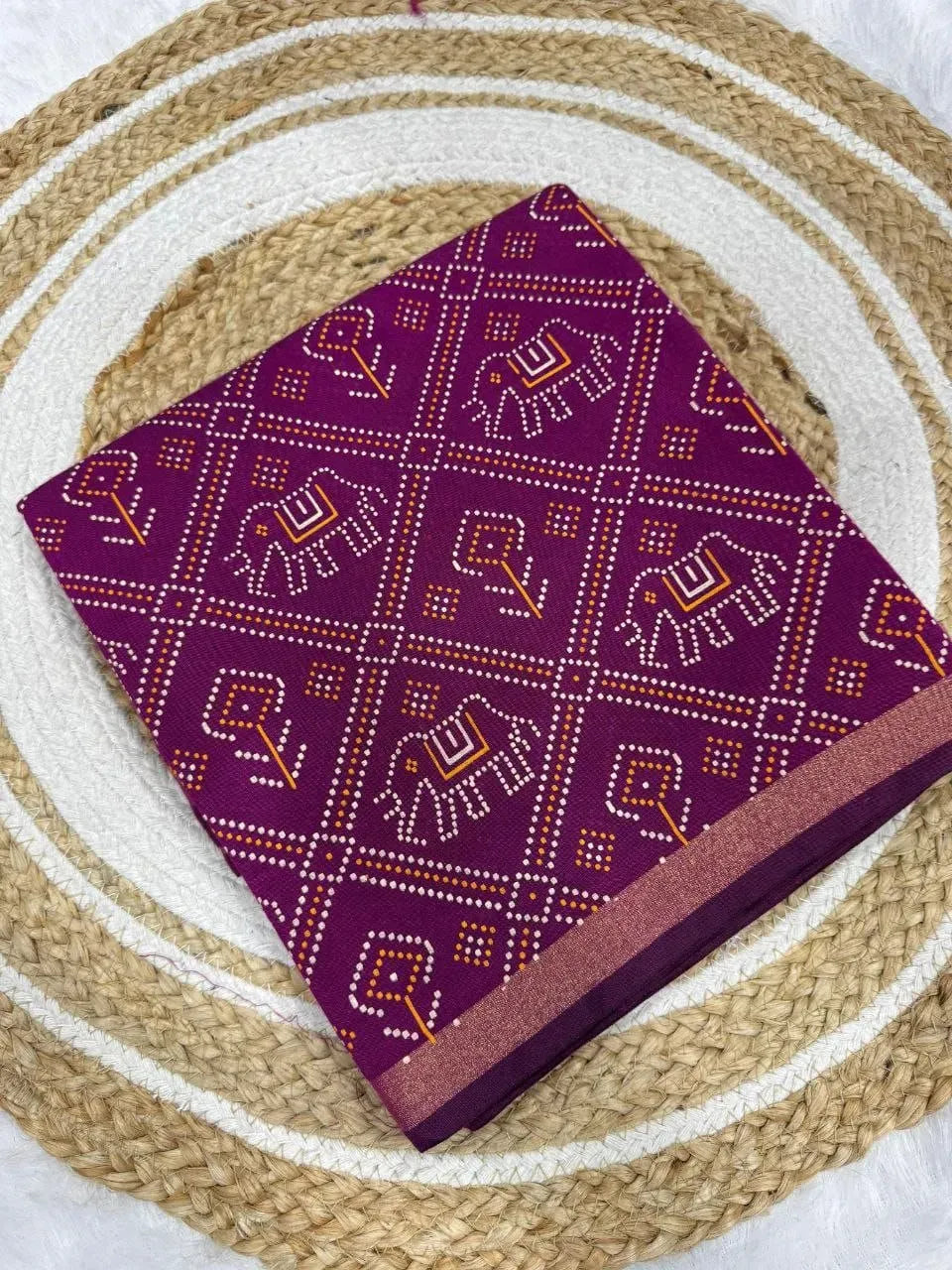 Purple Gadhval bandhani saree folded on round jute mat