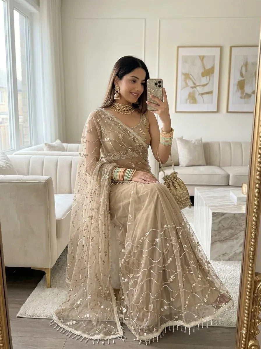 Model wearing beige heavy sequence work butterfly net saree indoors