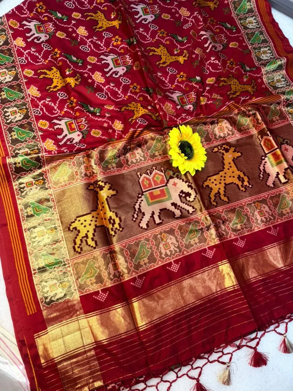 Red chanderi silk fabric featuring intricate traditional patterns and sunflower