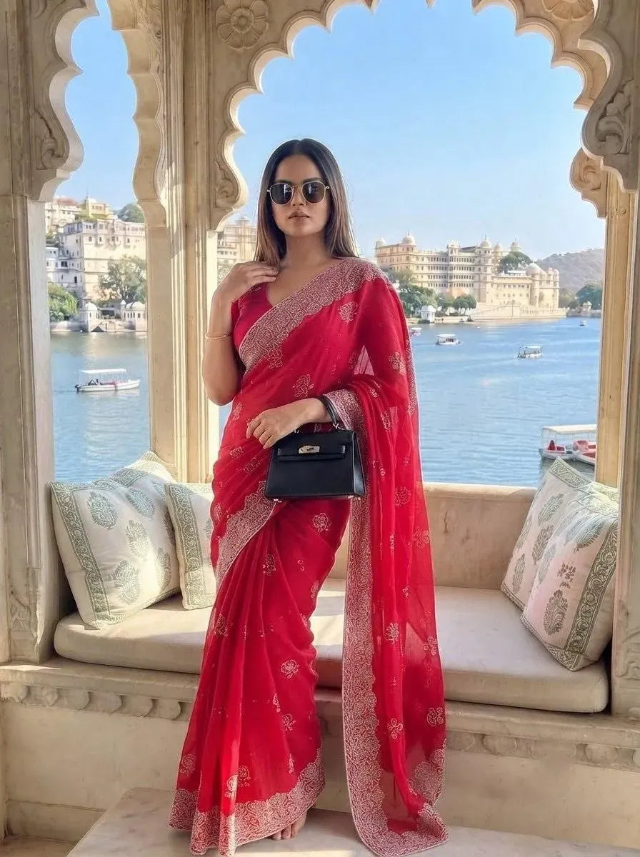 Model wearing red fendy chiffon silk saree with embroidery and cutwork border