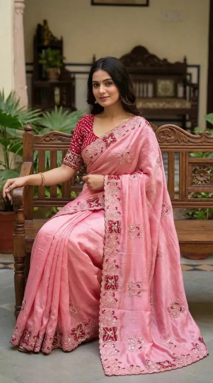 Model sitting gracefully in pastel pink designer chinon saree