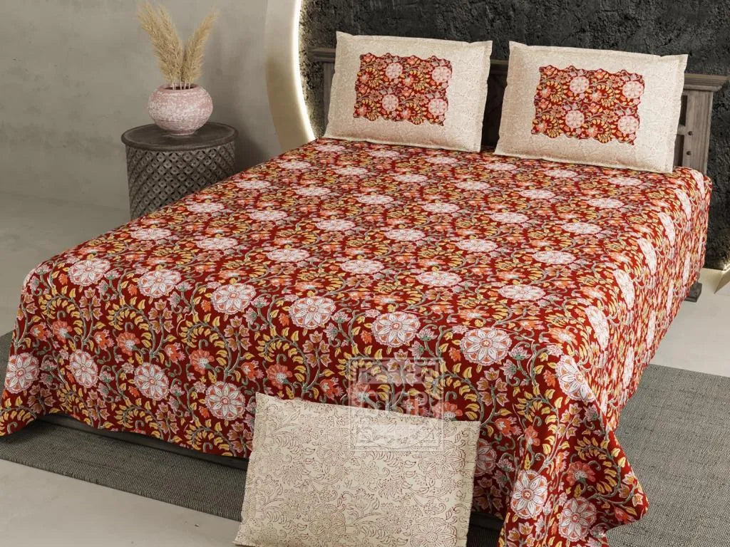 Red floral print cotton super king bedsheet with two matching pillow covers on bed