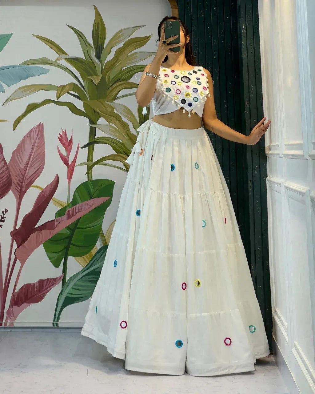 Off-white cotton tiered lehenga skirt with colorful mirror work and matching halter neck blouse on model