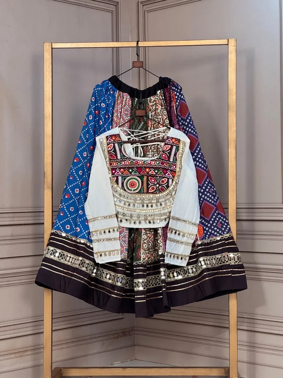 Multi-color cotton printed navratri lehenga paired with white embroidered blouse on hangers
