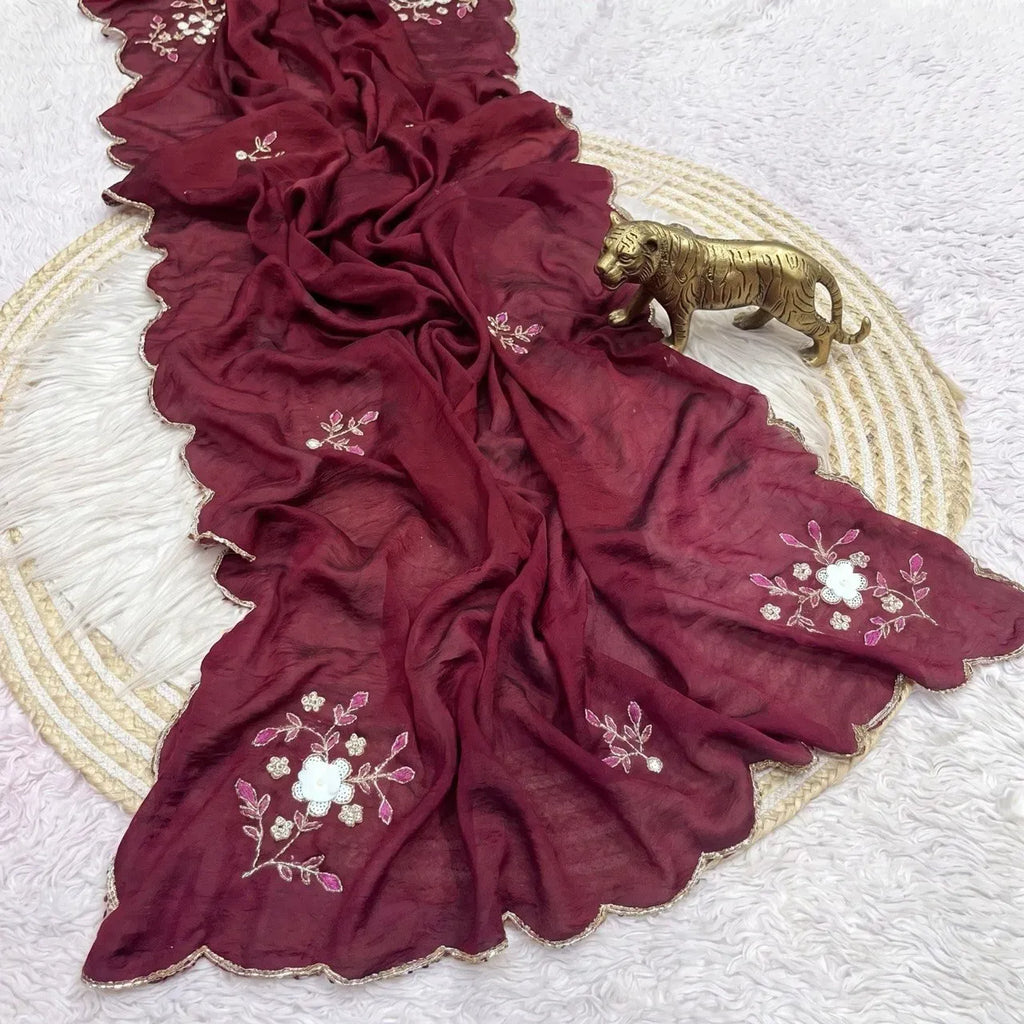 Deep wine crush silk saree with scallop cutdana border on white fur rug with brass tiger figurine