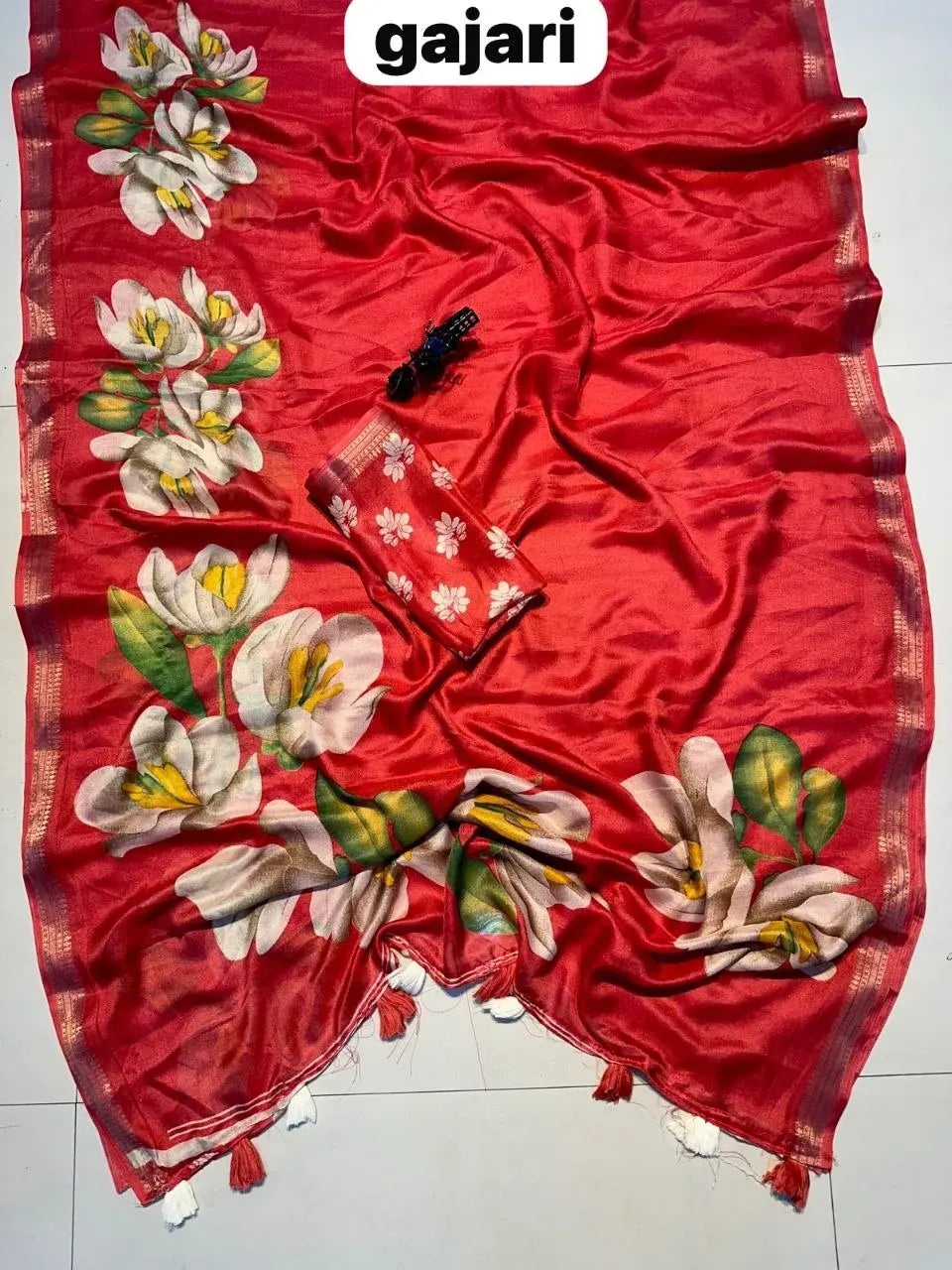 Red georgette saree laid out showing uniform floral design and unstitched blouse