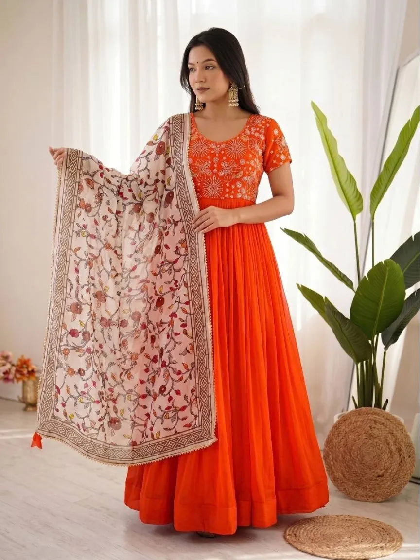 Woman in an orange georgette silk gown with gold beads work and a cream floral printed chinnon dupatta