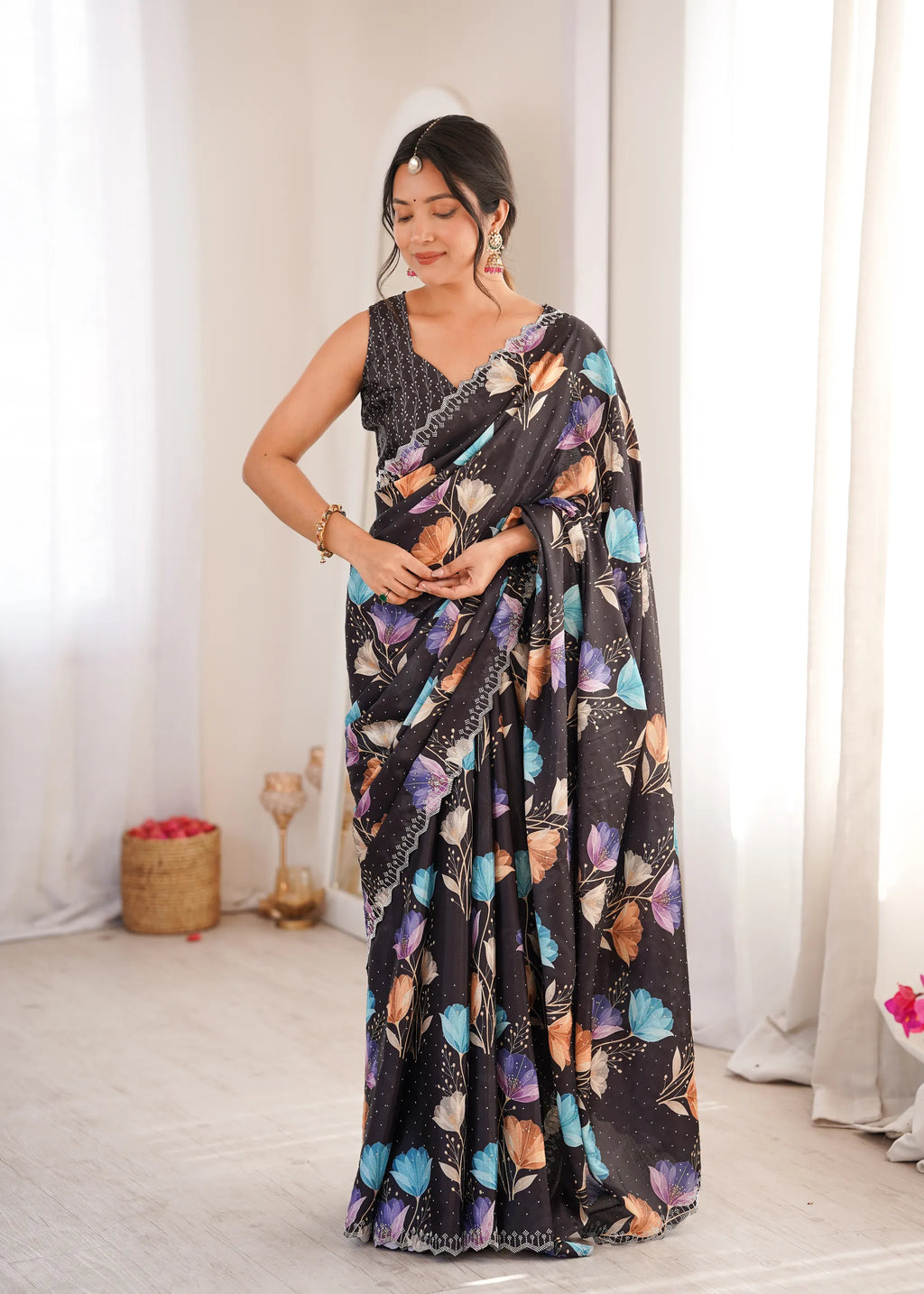 Front facing full body view of model wearing black floral print chinnon saree
