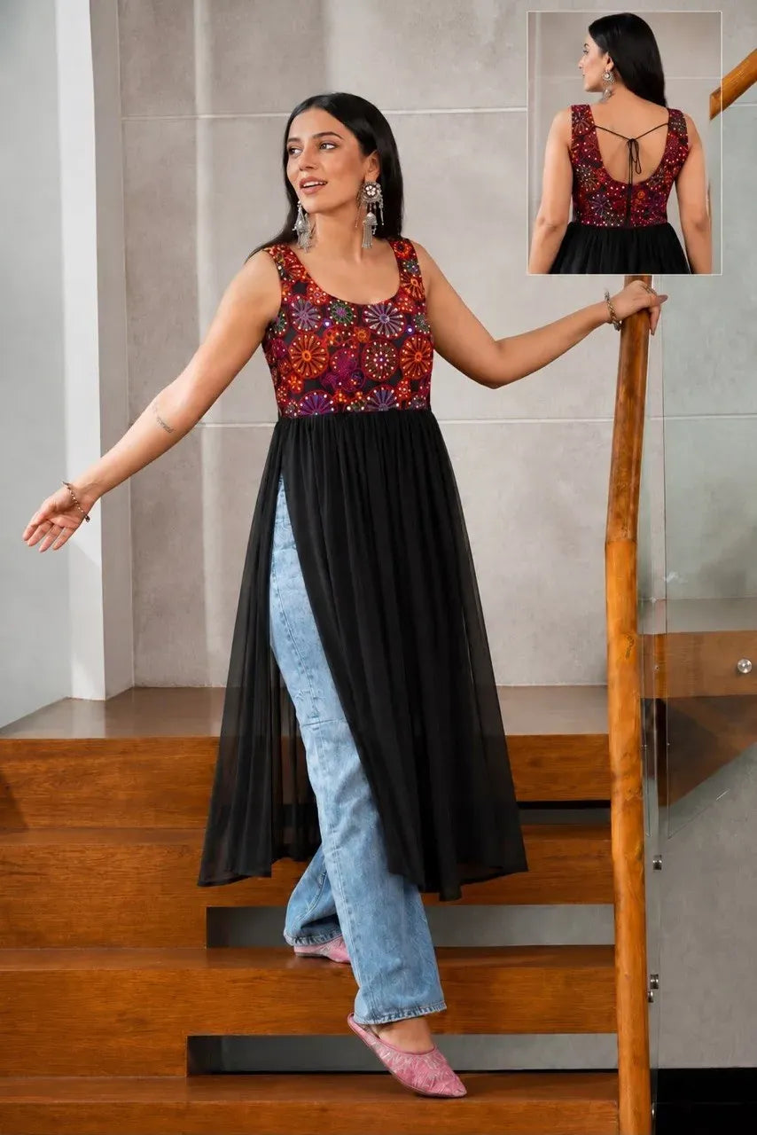 Model wearing black heavy georgette mirror work kurti with blue jeans on stairs