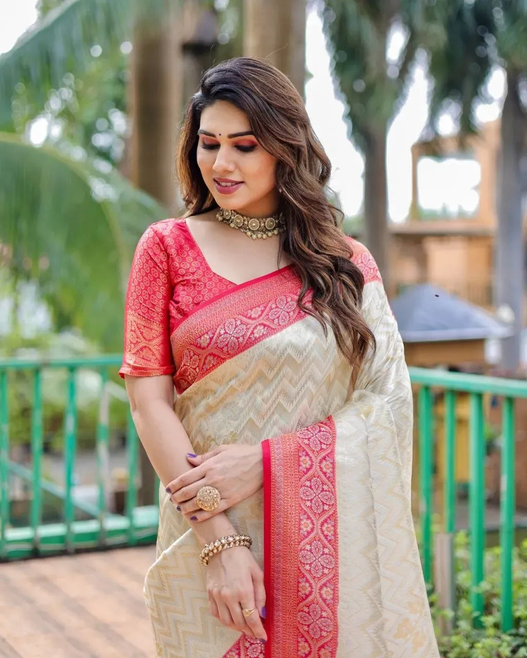 Woman wearing off white and red kanjivaram silk saree with zari border