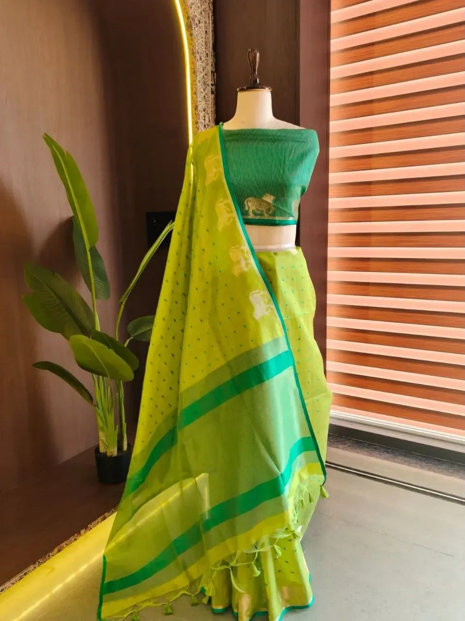 Neon green khadi raw silk saree with bandhni butti weaves on mannequin