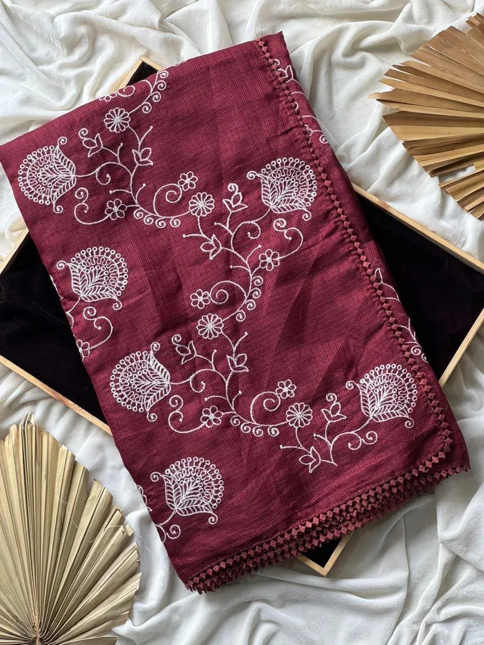 Maroon pure Kota Doriya saree folded neatly with white multi-thread zaal work and GPO lace border