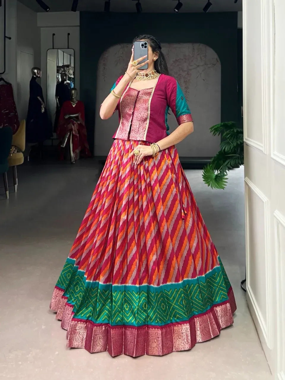 Model posing in pink and orange striped Leheriya print lehenga skirt with a matching pink zari woven blouse