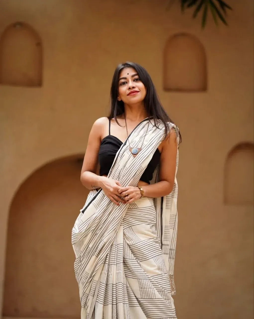 Front facing shot of model in a white and black digital printed linen cotton saree