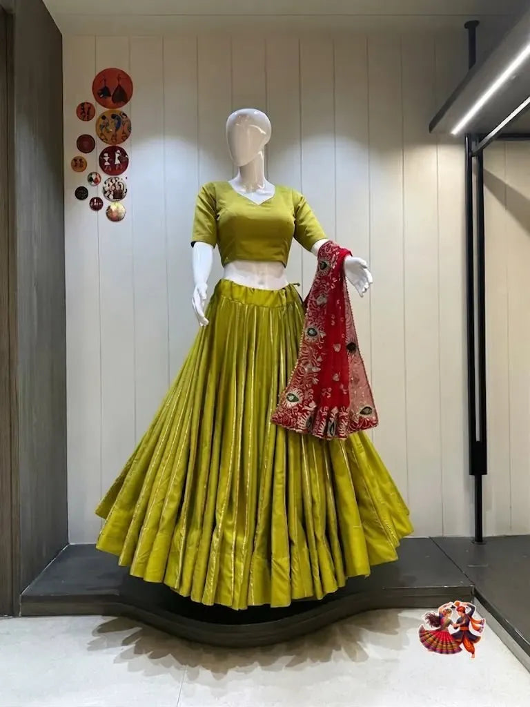Lime green rayon cotton lehenga skirt with gold stripes on mannequin paired with a red embroidered dupatta