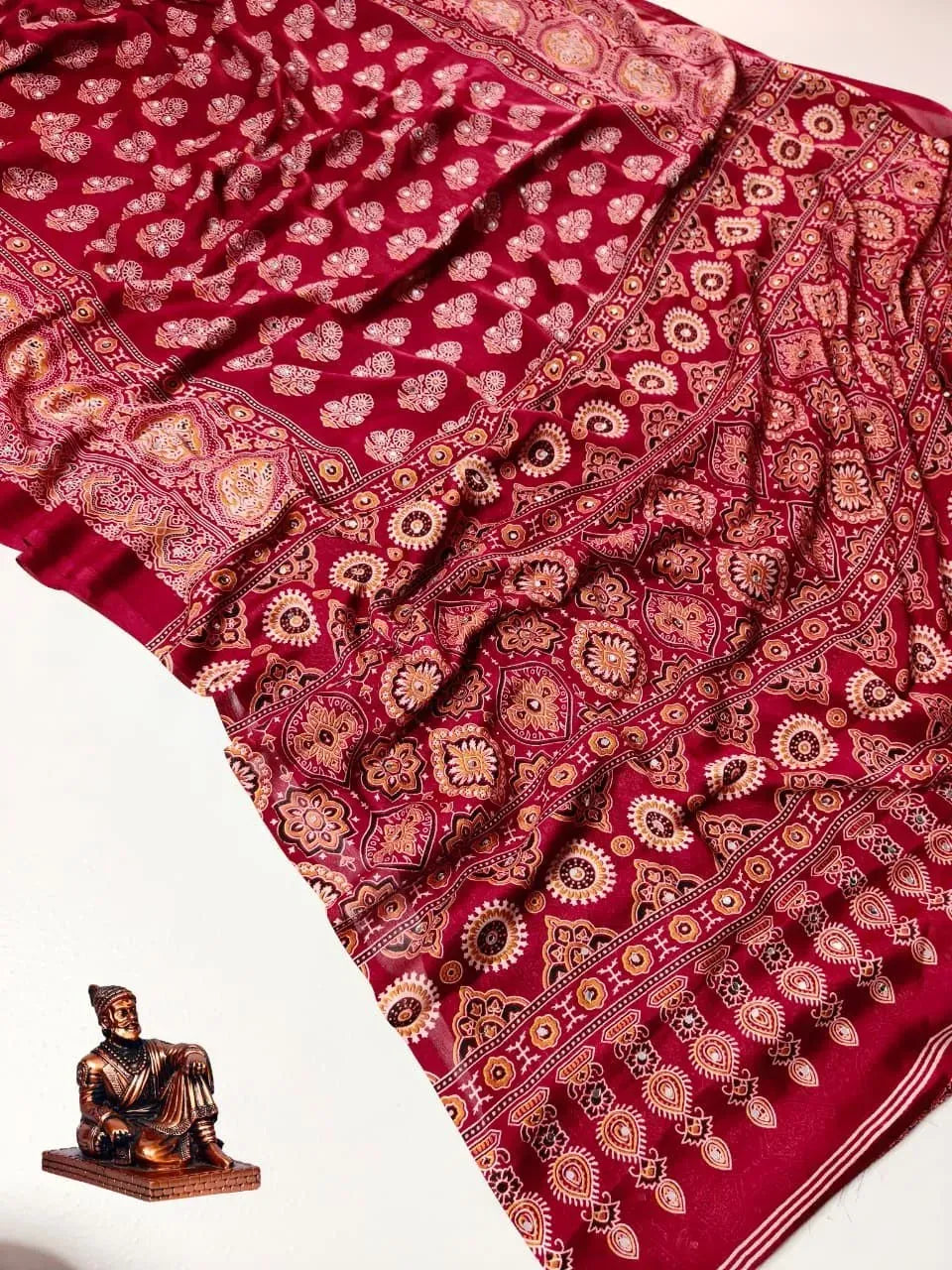 Red satin ajrak print saree with mirror work flat lay