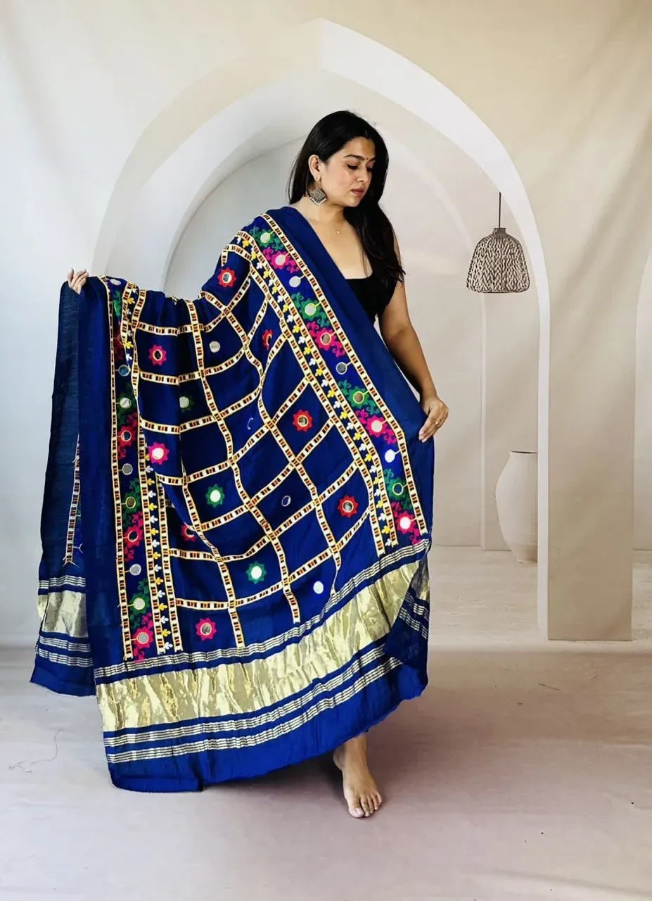 Woman in black top modeling a royal blue semi gajji dupatta decorated with colorful mirror work and golden border