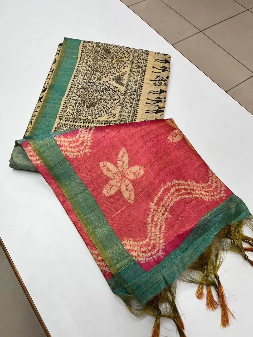 Folded pink and green tissue tussar silk saree with floral print pallu and tassels