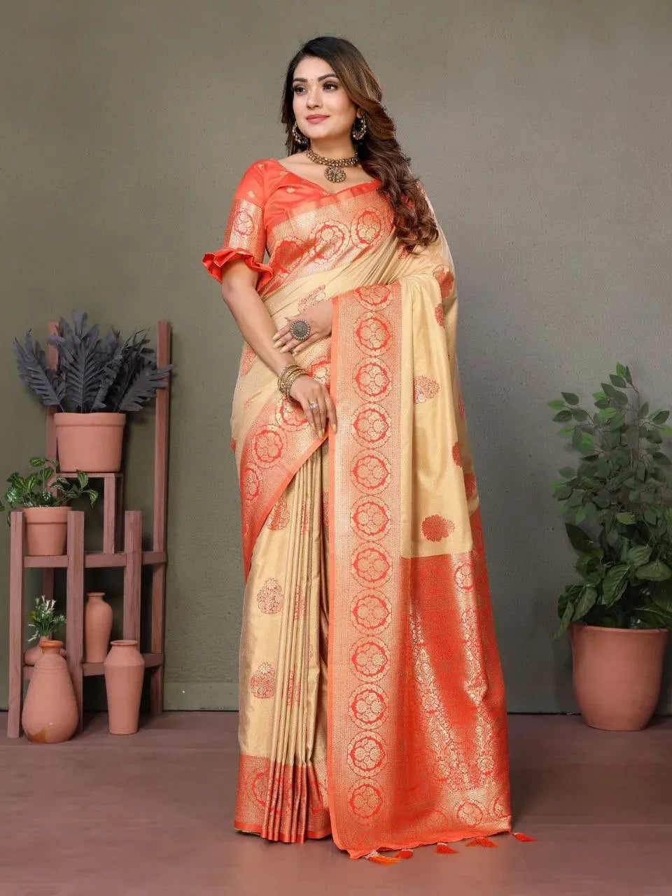 Front facing full body view of model in cream and orange viscose silk saree