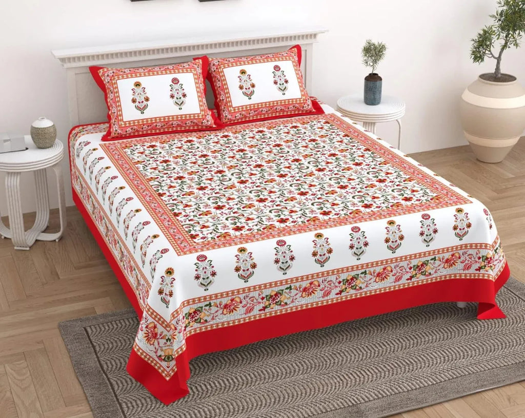 Red floral print pure cotton double bedsheet with two matching pillow covers on a wooden bed