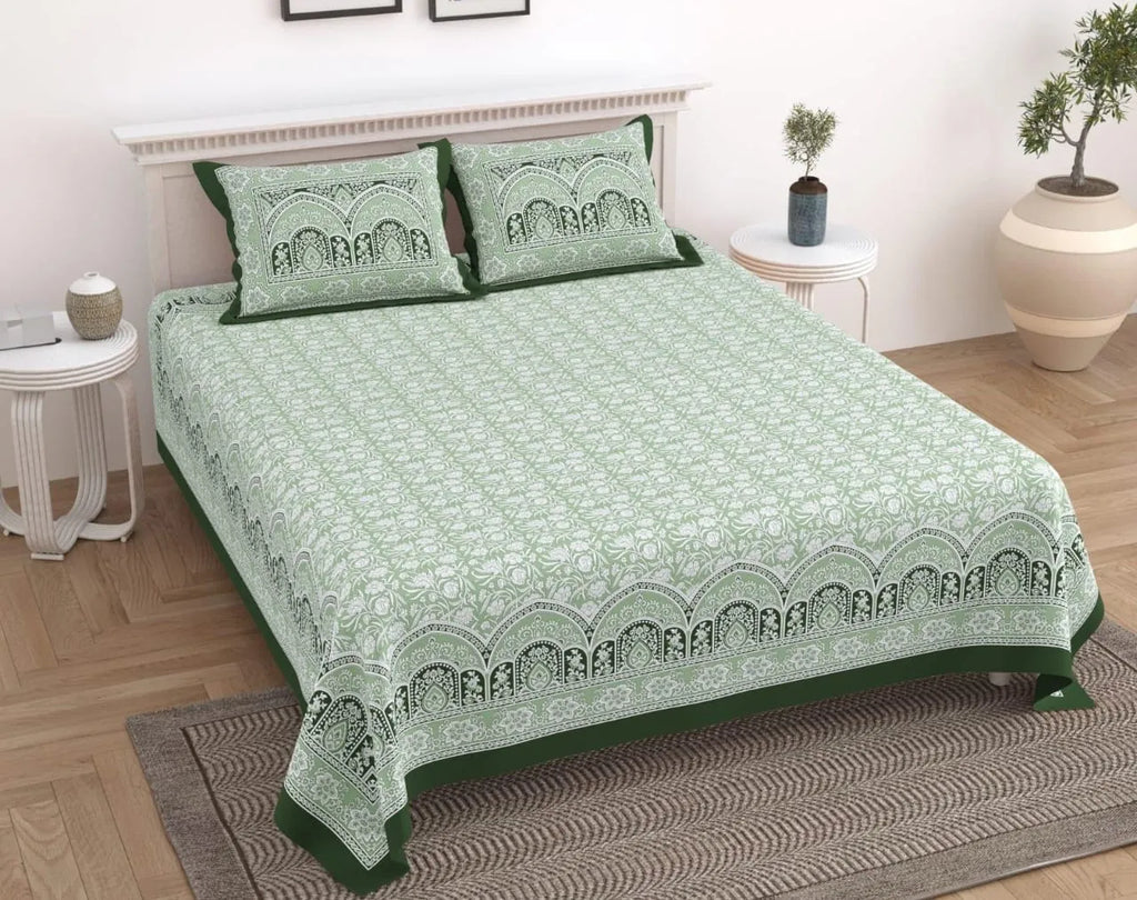 Sage green and white floral print cotton bedsheet with two matching pillow covers on bed