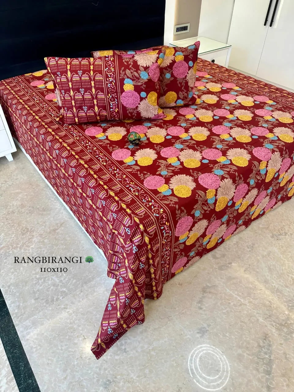 Maroon floral cotton super king bedsheet with two matching pillow covers on bed