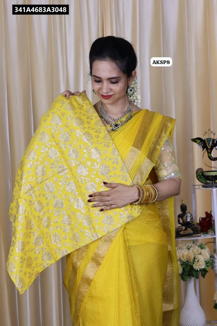 Woman wearing a yellow Pure Organza Checks Saree and holding its matching yellow Brocade Jacquard Blouse fabric.
