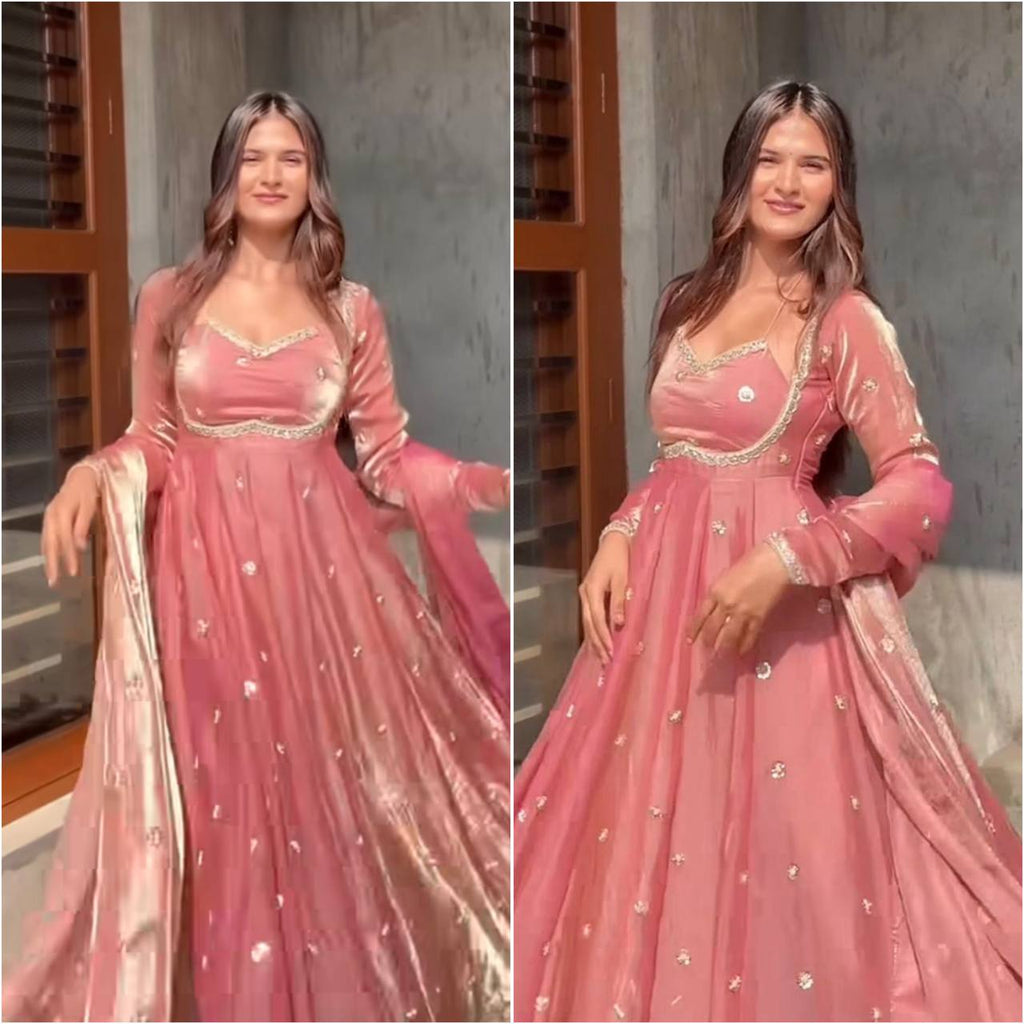 Model in a flowing blush pink Fendy Silk Anarkali dress with gold embroidery and sequence work, smiling.