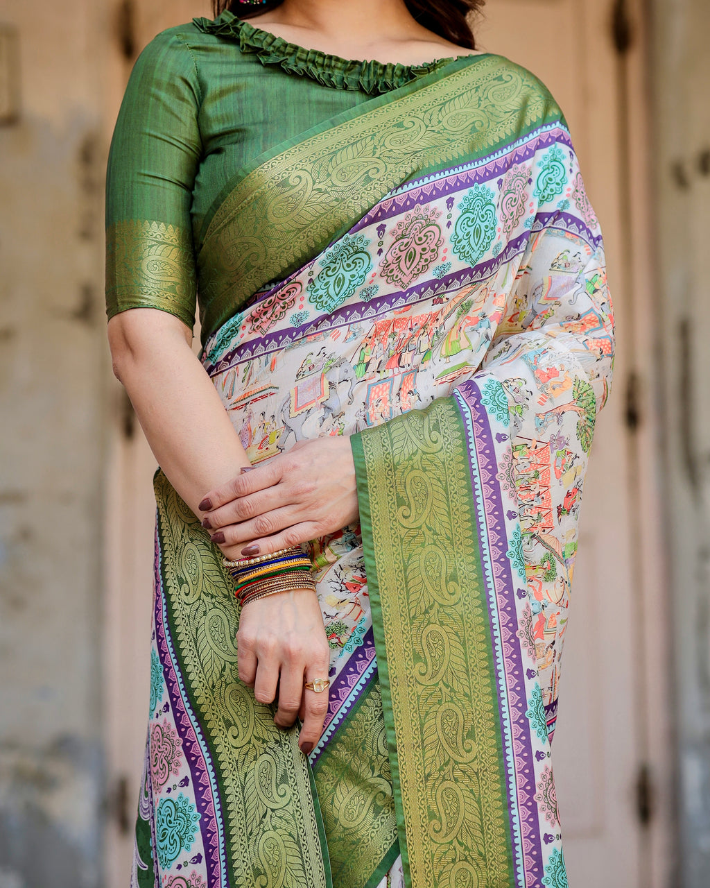 Close-up shot of the exquisite heritage-inspired digital print and ornate green zari border on a silk saree.