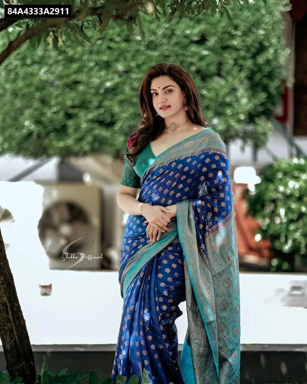 Woman in Royal Blue Lichi Silk Jacquard Saree with green blouse, full length outdoors.