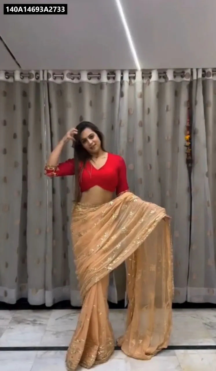 Full-body shot of a woman wearing a Peach Gold Georgette Saree with a red blouse, showcasing the drape and design.