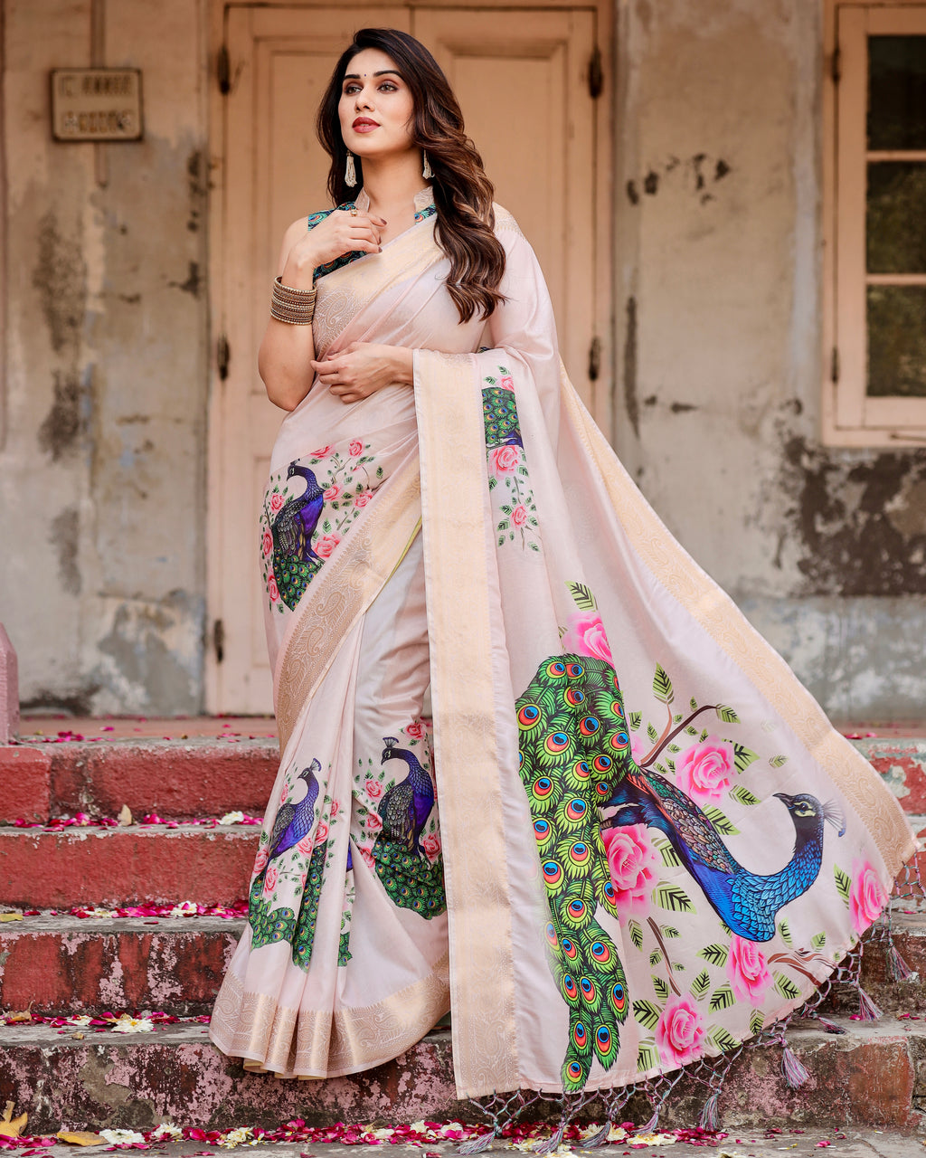 Elegant woman posing in an Ivory Soft Silk Saree with vibrant peacock and rose digital print, featuring gold zari borders, ideal for festive and wedding wear.