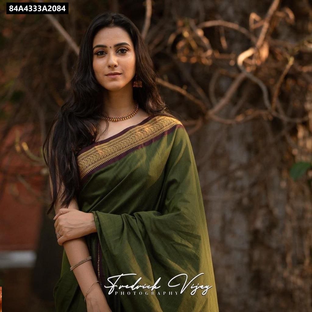 Front-facing model in dark olive green Lichi Silk Saree, looking at camera